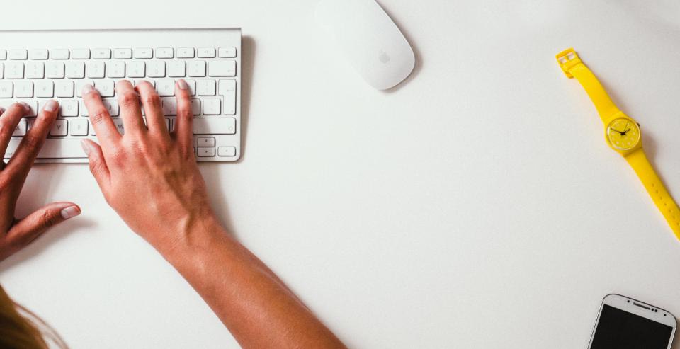 Hände tippen bei einer Online-Registrierung auf einer Tastatur