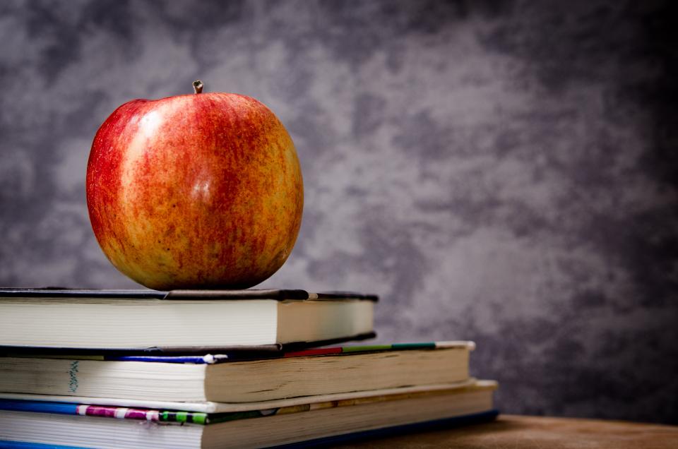 Roter Apfel auf einem Bücherstapel als Sinnbild für die Abiturnote
